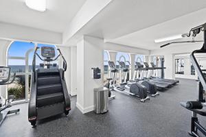 a gym with treadmills and ellipticals in a building at Calypso Resort by Panhandle Getaways in Panama City Beach
