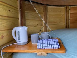 a tray with a coffee maker and cups on a bed at Moon Pod in Westfield