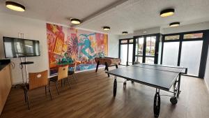 a room with a ping pong table and a tv at Kyriad Le Bourget Centre- Parc Des Expositions in Le Bourget