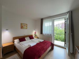 a bedroom with a large bed and a large window at Hotel Keltika in Izola