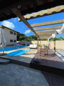 a patio with a pool and a wooden deck at Aruna Eco Pousada in Búzios