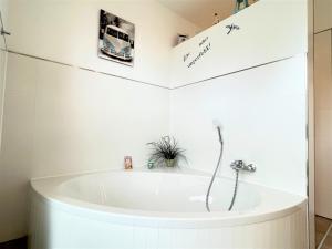 une baignoire dans une salle de bain avec un bus sur le mur dans l'établissement Haus Undine, Deichhörn 6a, à Dangast 35 autres photos