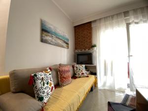 a living room with a couch and a television at Penny's luxury city apartment in Thessaloniki