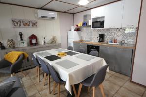 eine Küche mit einem Tisch und Stühlen in der Unterkunft Agréable Maison, DOMAINE TAMARIS, 4 pièces 6 couchages, Wifi, séjour climatisée, Accès payant pour les piscines- PORTIRAGNES PLAGE LRTAMJ21 in Portiragnes