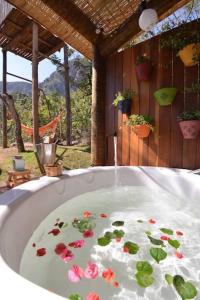 uma banheira com flores na água em Cabanas da Mata - Cabana Flamboyant - Casa Branca em Brumadinho