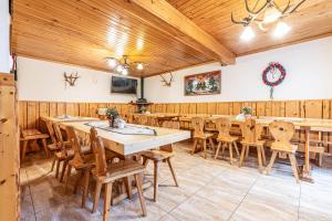 Dworek pod Tatrami في زومب: غرفة طعام مع طاولة وكراسي طويلة