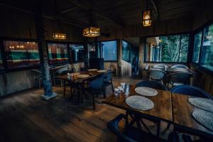 a restaurant with wooden tables and chairs and windows at Montana Suite Bungalows in Trabzon