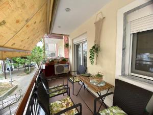 a balcony with a table and chairs and a television at Penny's luxury city apartment in Thessaloniki