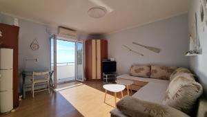 ein Wohnzimmer mit einem Sofa und einem Tisch in der Unterkunft Apartment with direct Sea View, Free Parking and close to Beaches and Promenade in Lovran