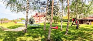 a yard with trees with hammocks and a house at bellavitavilla2020 in Siófok
