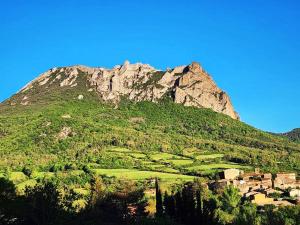 a mountain with a village in front of it at Cosy au pied du pic bugarach in Bugarach