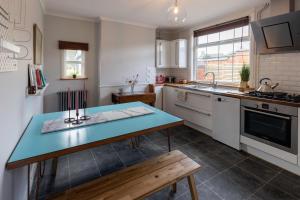 a kitchen with a blue table and a sink at Bijou cottage in a super location… ! in Sileby