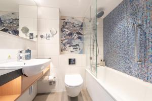 a bathroom with a sink and a toilet and a tub at Holiday Inn Edinburgh Zoo, an IHG Hotel in Edinburgh