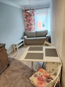 a living room with a table and a couch at Apartament w Centrum in Duszniki Zdrój