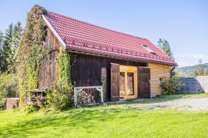 ein altes Holzhaus mit rotem Dach in der Unterkunft Willa Zwolakówka in Istebna