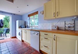 a kitchen with a sink and a dishwasher at Avocet Cottage in Dersingham