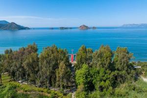 an aerial view of the ocean with trees and a red train at Lykia Botanika Beach Fun & Club - All Inclusive in Fethiye