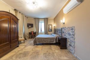 ein Schlafzimmer mit einem Bett und einer Steinmauer in der Unterkunft Agriturismo Parco delle Querce in Valentano