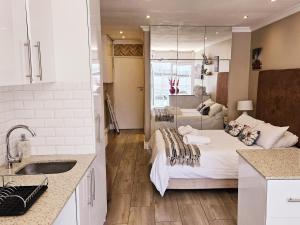 1 dormitorio grande con 2 camas y cocina en Studio 37 Hyde Park Apartments, en Ciudad del Cabo