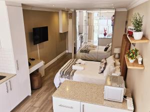 Una habitación con dos camas y un televisor. en Studio 37 Hyde Park Apartments, en Ciudad del Cabo