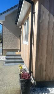 a building with a flower pot in front of it at Burnbrae Apartment in Portree