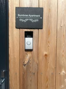 una cerradura en una puerta de madera con una cámara. en Burnbrae Apartment en Portree