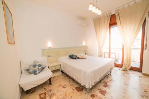 een slaapkamer met 2 bedden en een stoel bij Le Case della Costa - Appartamento Ravello in Maiori