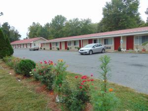 um carro estacionado num parque de estacionamento em frente a um motel em Red Carpet Inn Duncannon em New Buffalo