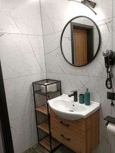 a bathroom with a sink and a mirror at Noclegi SKORUSINKA w pobliżu Chochołowskich Term in Witów