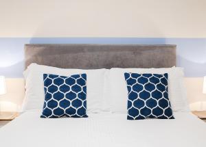 - un lit avec des oreillers blancs et bleus dans l'établissement Royal Ashton Townhouse - Taunton, à Taunton