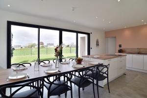 ein Esszimmer mit Tisch und Stühlen in einer Küche in der Unterkunft Villa Armor Glaz - Maison avec jacuzzi in Saint-Cast-le-Guildo