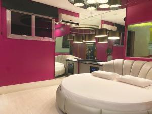 a bedroom with a white bed and a pink wall at Baviera Motel by Drops in Genuino Sampaio