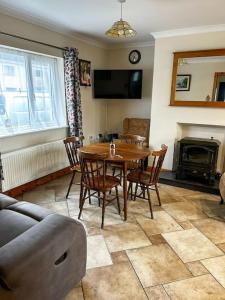 uma sala de estar com uma mesa de madeira e cadeiras em Marian Place House em Cahersiveen