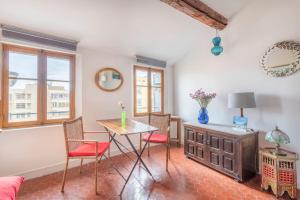 a living room with a table and chairs and a couch at Le Caisserie - Cosy studio Marseillais - Panier in Marseille