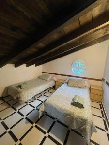 um quarto com 2 camas num piso de azulejo em CASA UMBRIA em Yunquera