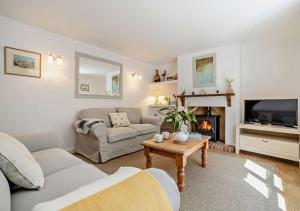 ein Wohnzimmer mit einem Sofa und einem Kamin in der Unterkunft Bay Tree Cottage - Dersingham in Dersingham