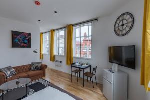 a living room with a couch and a tv at Pass the Keys Spacious Flat in Bradford in Birmingham