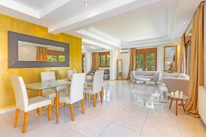 a dining room with a glass table and white chairs at Prestige Residence Rhodes in Ialysos