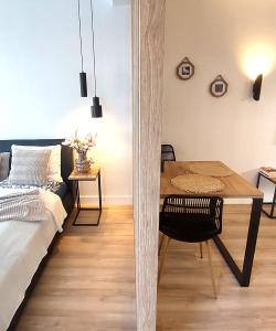 uma sala de estar com uma mesa e uma cama em DOBRUK APARTAMENTY Natalia apartament prywatny w hotelu Royal Tulip Sand em Kolobrzeg