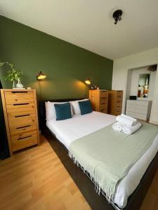 ein Schlafzimmer mit einem großen Bett und einer grünen Wand in der Unterkunft richmond park top floor in London