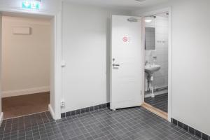 een badkamer met een toilet, een deur en een wastafel bij Castle House Inn in Stockholm