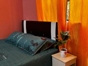 Kampung Bota Kiri的住宿－Marbel Villa，一间卧室配有一张带枕头和盆栽的床铺