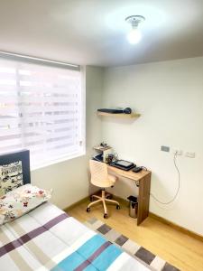 a bedroom with a desk and a bed and a window at Apartaestudio central en Bogotá in Bogotá