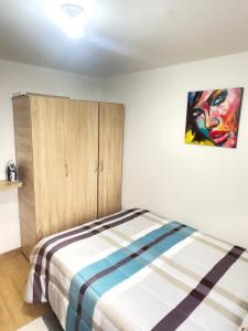 a bedroom with a bed and a painting on the wall at Apartaestudio central en Bogotá in Bogotá