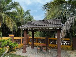Kampung Bota Kiri的住宿－Marbel Villa，木制凉亭配有桌子和长凳