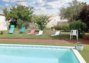 eine Gruppe von Stühlen neben einem Swimmingpool in der Unterkunft Studio cosy avec jardin, La Jarrie, 23m², piscine partagée in La Jarrie
