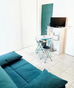ein Wohnzimmer mit einem Tisch, einem Tisch und einem Stuhl in der Unterkunft Studio cosy avec jardin, La Jarrie, 23m², piscine partagée in La Jarrie