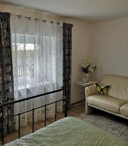 um quarto com uma cama, um sofá e uma janela em Ferienwohnung am Pilsensee em Seefeld