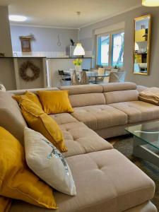 a living room with a brown couch and yellow pillows at The Lovely Garden House in Zagreb