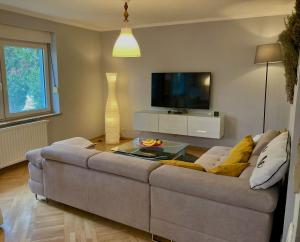 uma sala de estar com um sofá e uma televisão em The Lovely Garden House em Zagreb